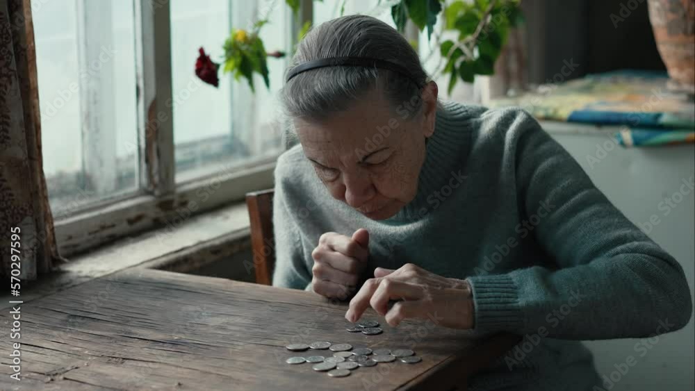 Poor old woman counting coins on a table Poor old woman counting coins on a table