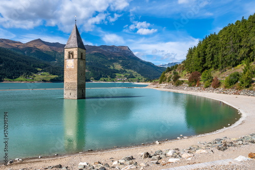 The bell tower of the church remains from the flooded village Graun - Curon in Val Venosta, South Tyrol, Italy