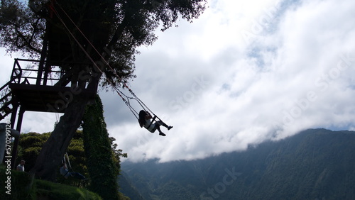 Person in silhouette swinging on the "Swing at the End of the World" at the Casa de Arbol, in Banos, Ecuador
