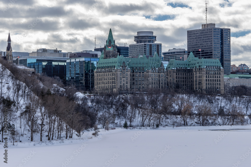 Having a walk through the Majors Hill Park in downtown Ottawa Canada with view to the historical buildings of the Canadian parliament and its surroundings at a cold but sunny day in winter.