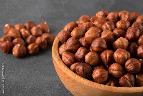 View of a bowl full of hazelnuts on a black background 