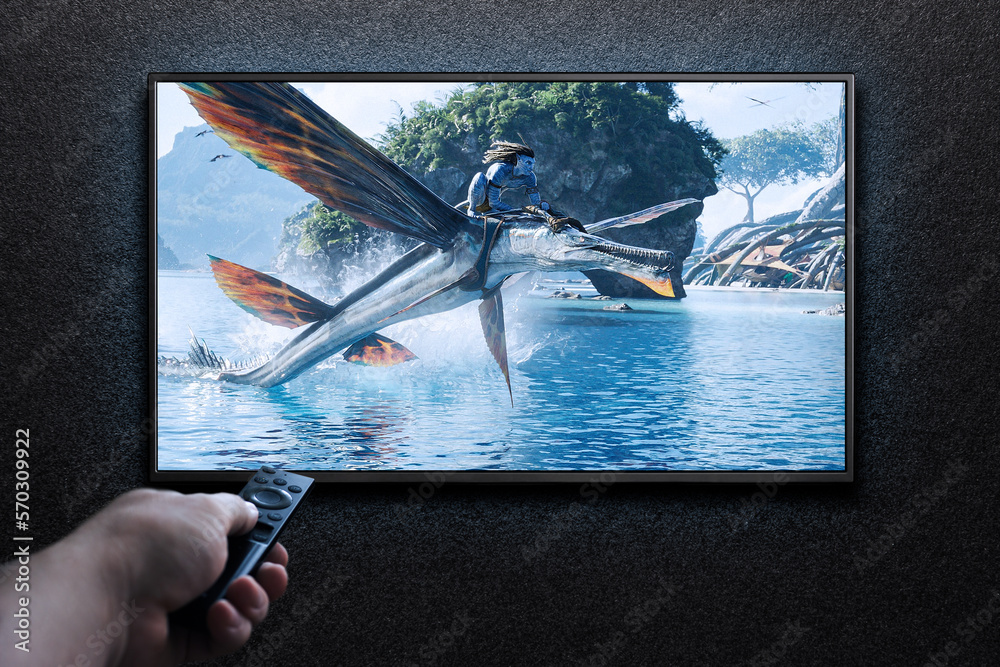 Man turns on TV with remote control. TV screen playing Avatar the way ...
