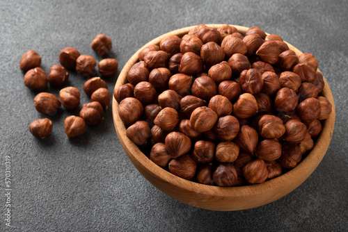 View of a bowl full of hazelnuts on a black background 