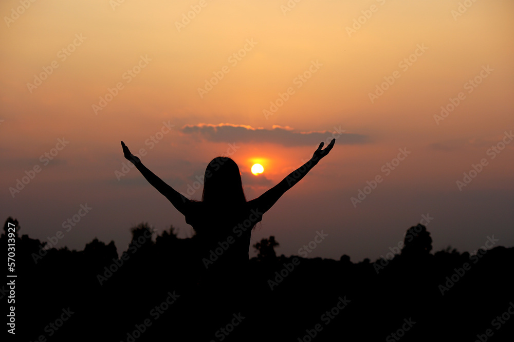 silhouette of human hand raised to make a wish, sunset background silhouette of human hand raised to make a wish, sunset background