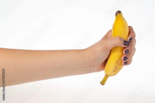 Hand holding whole banana isolated on white background