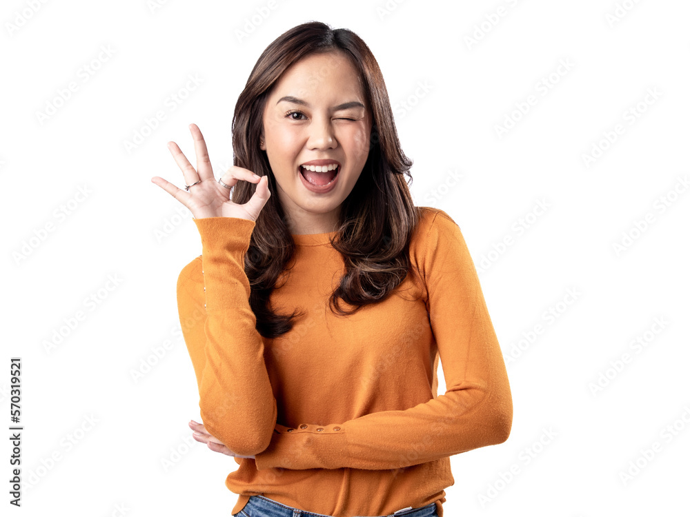 A portrait of a happy Asian Indonesian woman wearing an orange sweater and displaying the OK hand sign, isolated on a white background A portrait of a happy Asian Indonesian woman wearing an orange sweater and displaying the OK hand sign, isolated on a white background