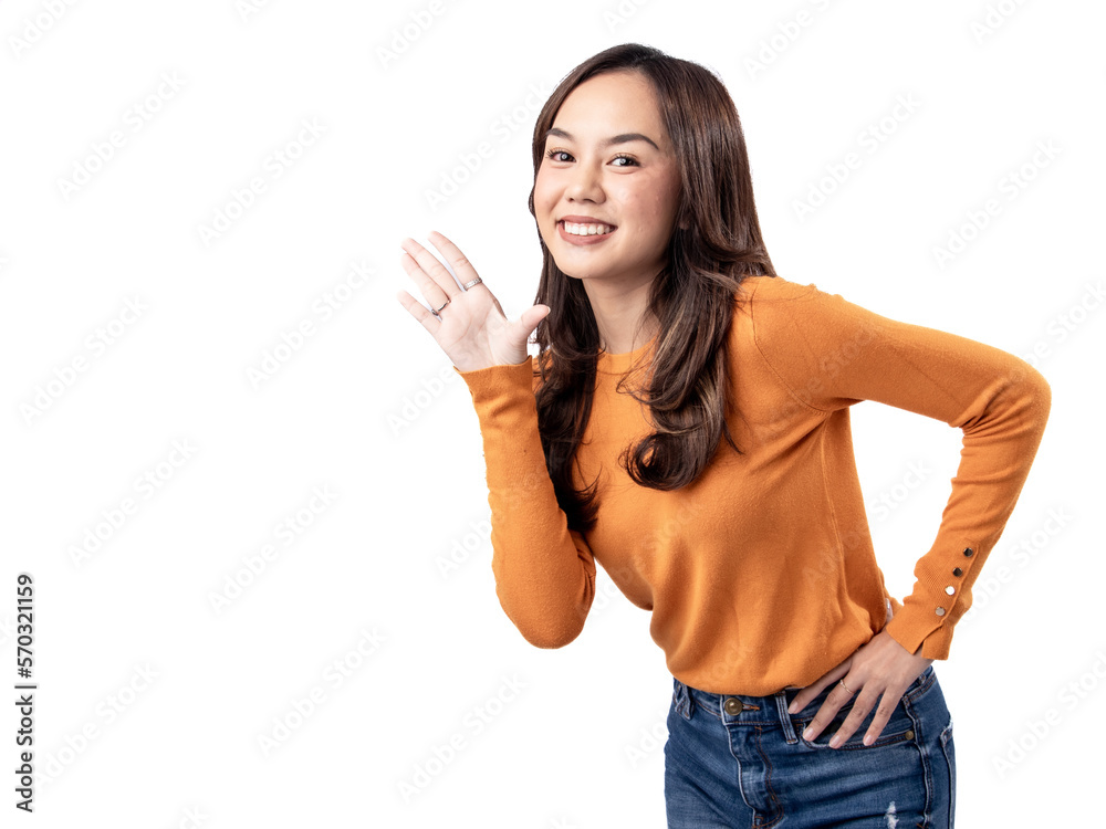 Photo features a happy Indonesian woman wearing an orange sweater and jeans appearing to be greeting someone, isolated on a white background. Photo features a happy Indonesian woman wearing an orange sweater and jeans appearing to be greeting someone, isolated on a white background.