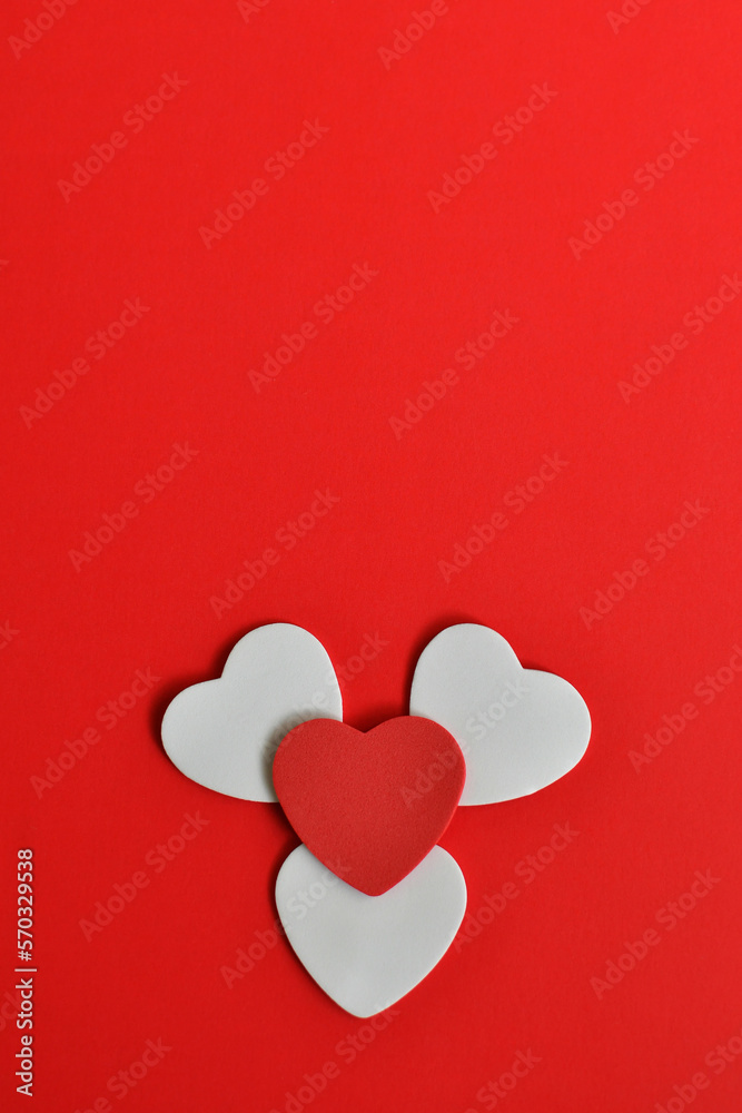 Figura de corazones blancos y rojo, aislados sobre un fondo rojo, espacio para texto en la parte superior.
