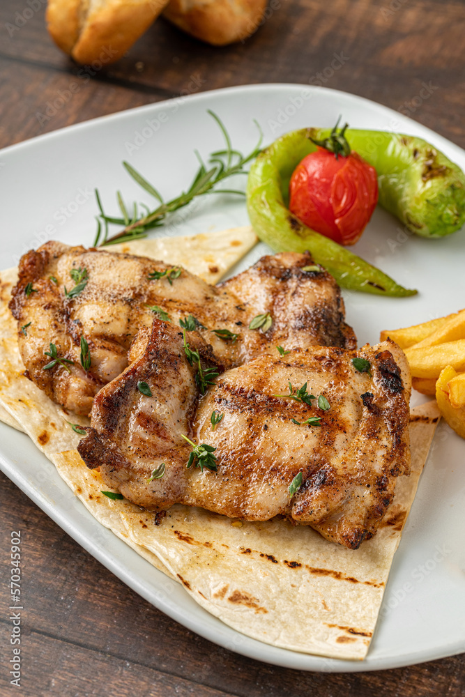 Spicy grilled chicken on a white porcelain plate Spicy grilled chicken on a white porcelain plate