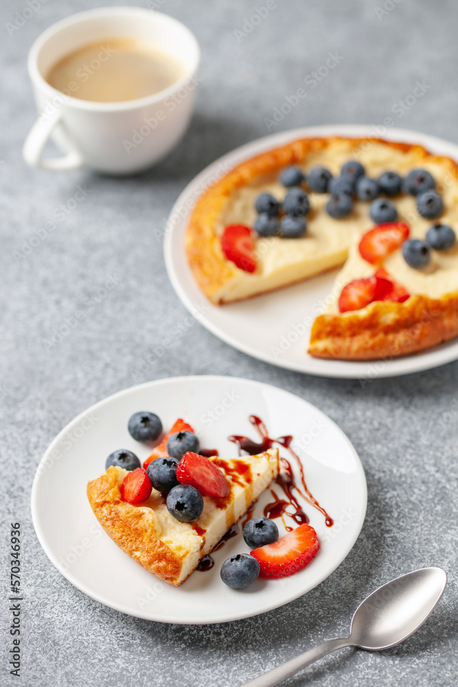 Curd casserole piece in a plate with berries on the table. Curd casserole piece in a plate with berries on the table.