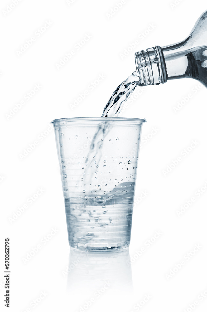 Pouring water into disposable plastic cup on a white background Pouring water into disposable plastic cup on a white background