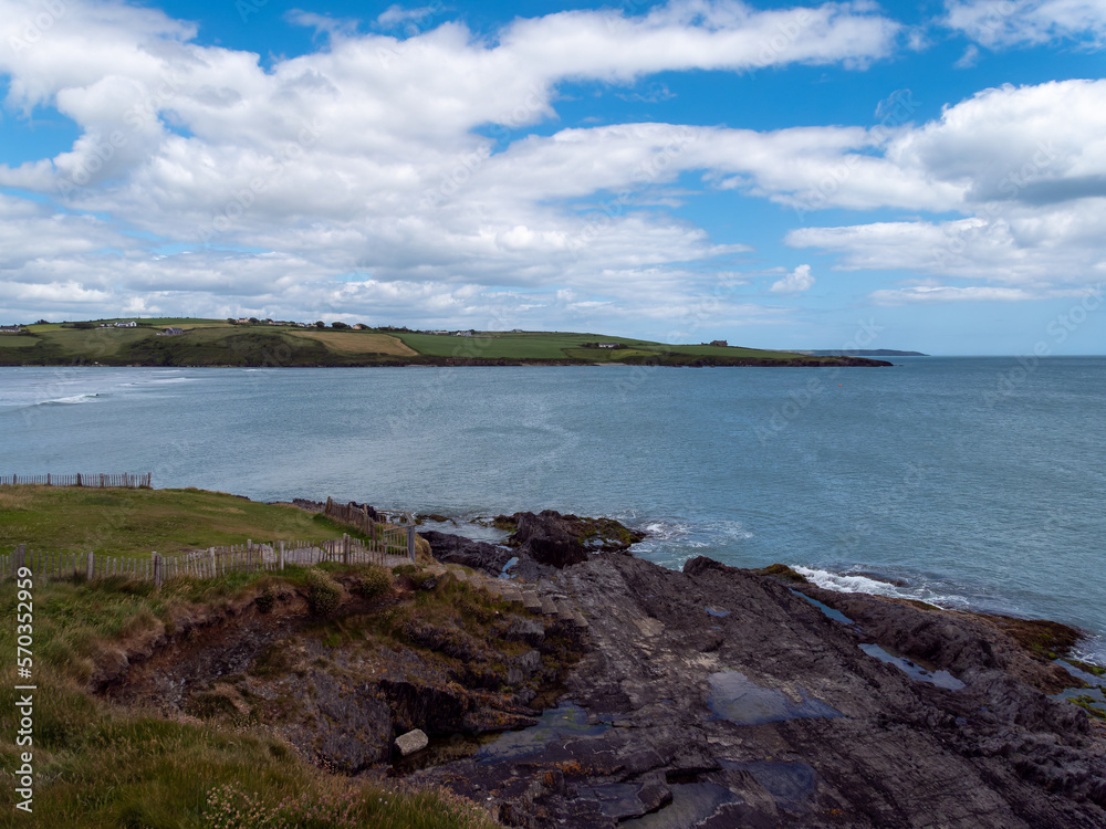Clonakilty Bay under a cloudy sky on a summer day. Irish seascape, body of water under blue sky. Clonakilty Bay under a cloudy sky on a summer day. Irish seascape, body of water under blue sky.