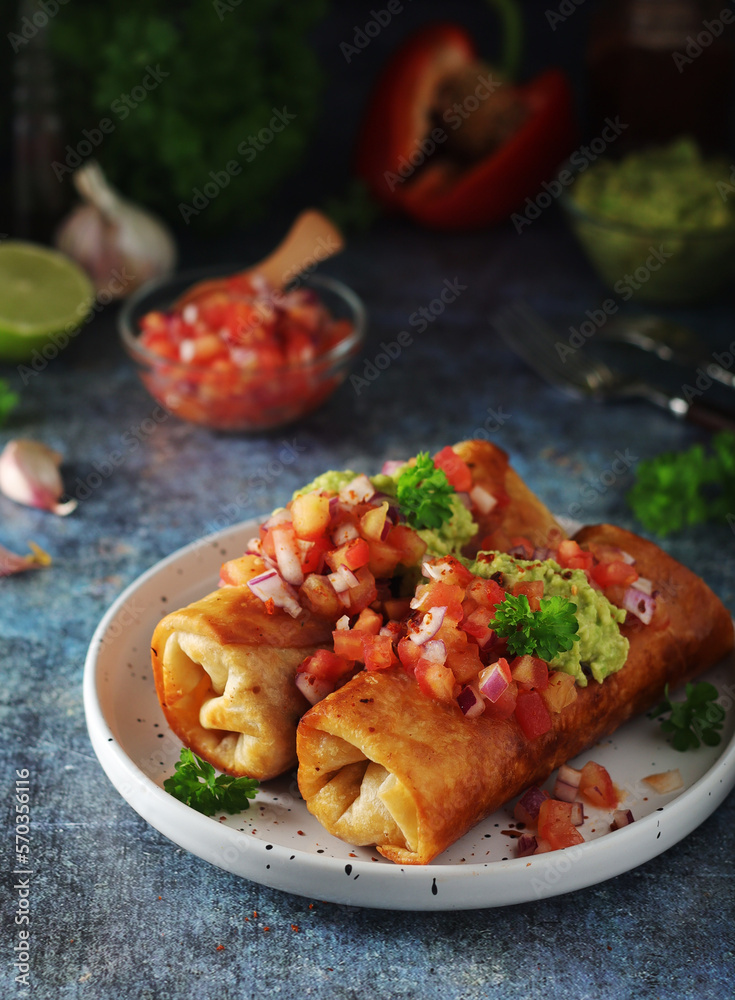 A typical dish of Mexican cuisine - Chimichanga, made of tortilla with different ingredients A typical dish of Mexican cuisine - Chimichanga, made of tortilla with different ingredients