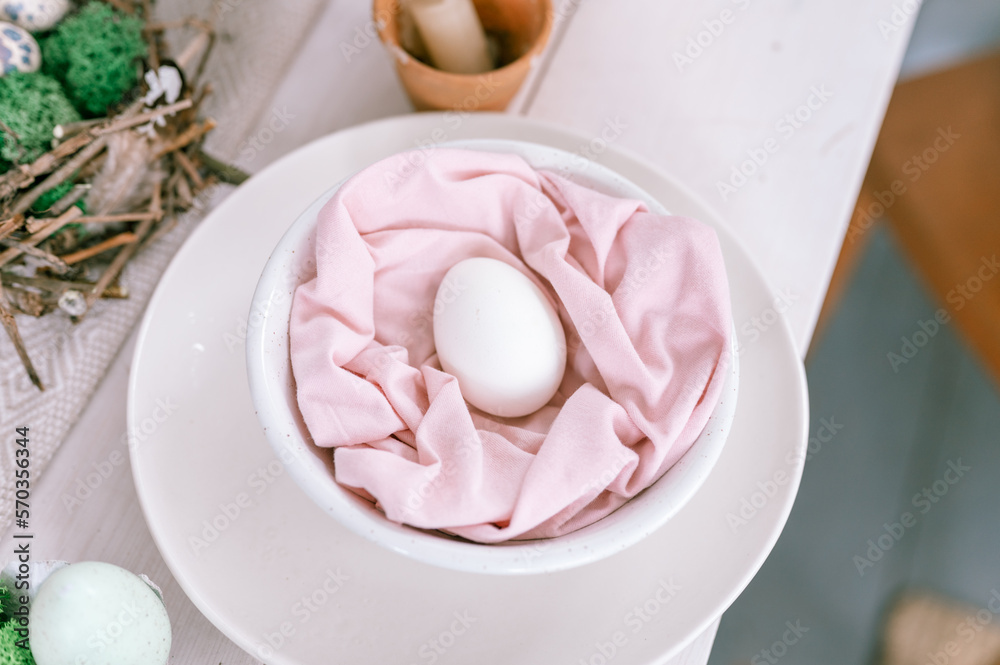 happy easter holiday in springtime season. festive home decor. traditional food. natural white chicken egg in pastel pink fabric in a plate on the table