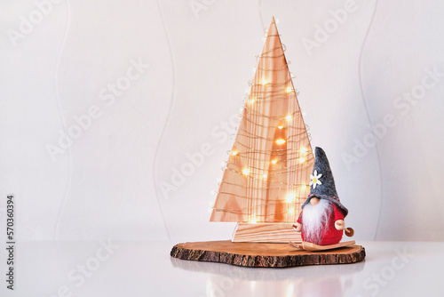 Christmas gnome on skiing, Christmas wooden tree, on tree cut. Christmas interior decor. photo