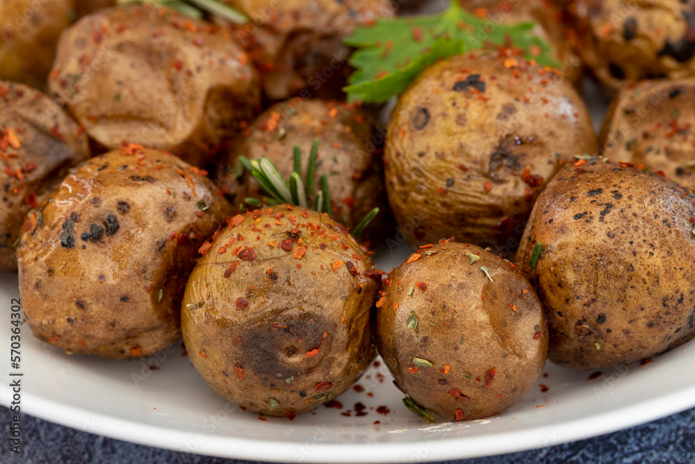 Fried (baked) whole small potatoes with rosemary and salt in a frying pan, ruddy crust, appetizing food Fried (baked) whole small potatoes with rosemary and salt in a frying pan, ruddy crust, appetizing food