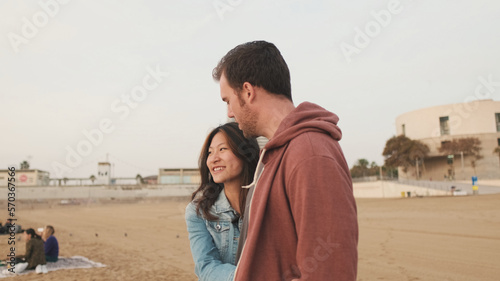 Man and woman talking while standing on the beach