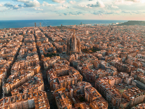 Aerial view of Barcelona City Skyline and Sagrada Familia Cathedral at sunset. Eixample residential famous urban grid. Cityscape with typical urban octagon blocks