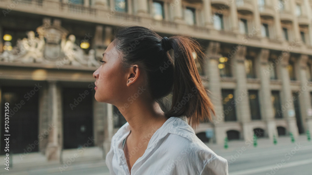 Young woman walks down the street and looks around Young woman walks down the street and looks around