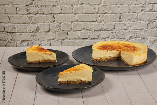 cheesecake and slices on a white brick wall