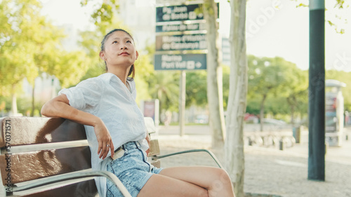 Young woman resting on bench on the street of the old city © Andrii Nekrasov