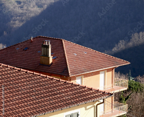 Houses with tiled roof and chimney in a mountainous area
