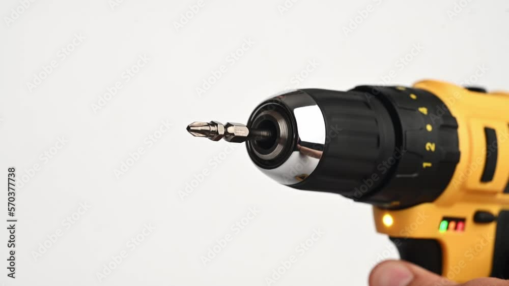 A rotating chisel on a yellow cordless electric screwdriver on a white background. Close-up. The concept of construction, repair, electrical equipment, modern tools. A rotating chisel on a yellow cordless electric screwdriver on a white background. Close-up. The concept of construction, repair, electrical equipment, modern tools.