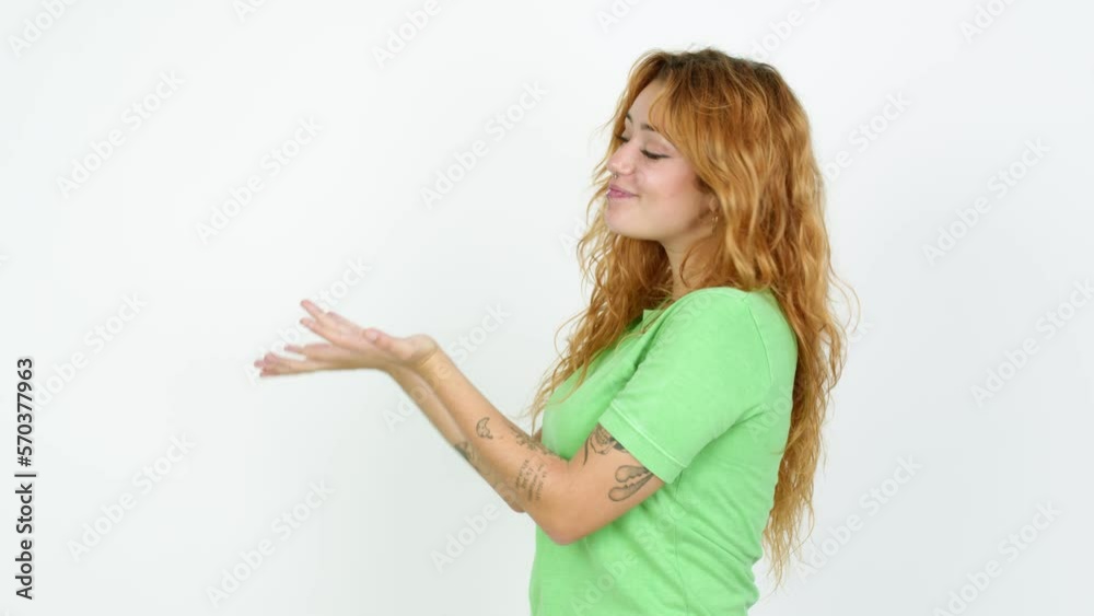 Young redhead woman extending hands to the side and inviting to come over isolated background Young redhead woman extending hands to the side and inviting to come over isolated background