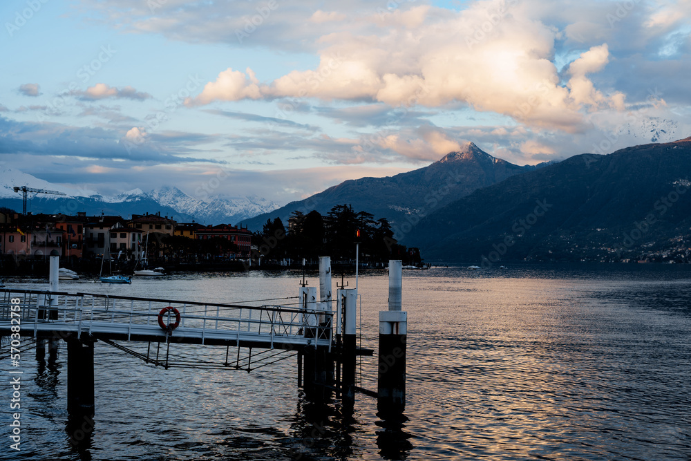 Pier on the background of the ancient town of Menaggio at dusk. Como, Italy