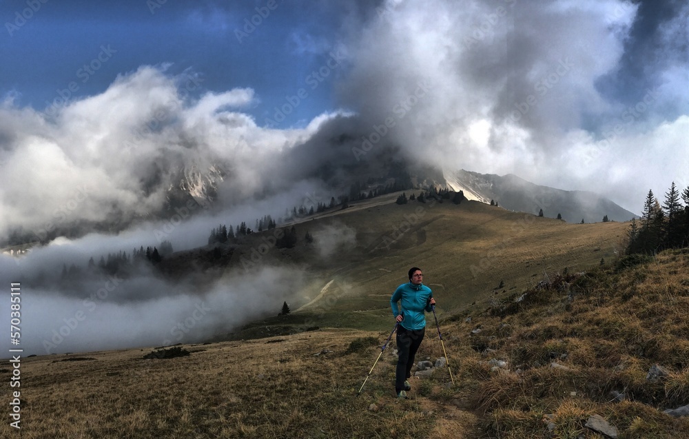 Bergwanderer (weiblich) zwischen Wolken und Nebelschwaden beim Aufstieg auf Peitingköpfl und Sonnstagshorn, Heutal, Unken, Alpen, Tirol, Österreich
