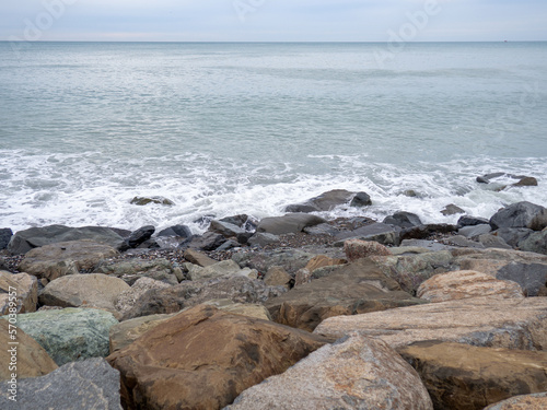 resort in winter. The rocky shore is washed by the waves in cloudy weather. Black Sea coast. The coast of Batumi. Nature in shades of grey. boring landscape