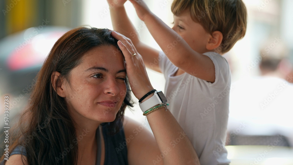 2 year old little boy tapping mother head. Cute casual family lifestyle moment. Kid drumming parent top of head 2 year old little boy tapping mother head. Cute casual family lifestyle moment. Kid drumming parent top of head