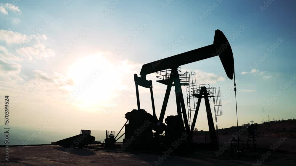 Oil worker standing among the oil pump jacks. Oil industry, crude oil prices concept. Oil worker standing among the oil pump jacks. Oil industry, crude oil prices concept.