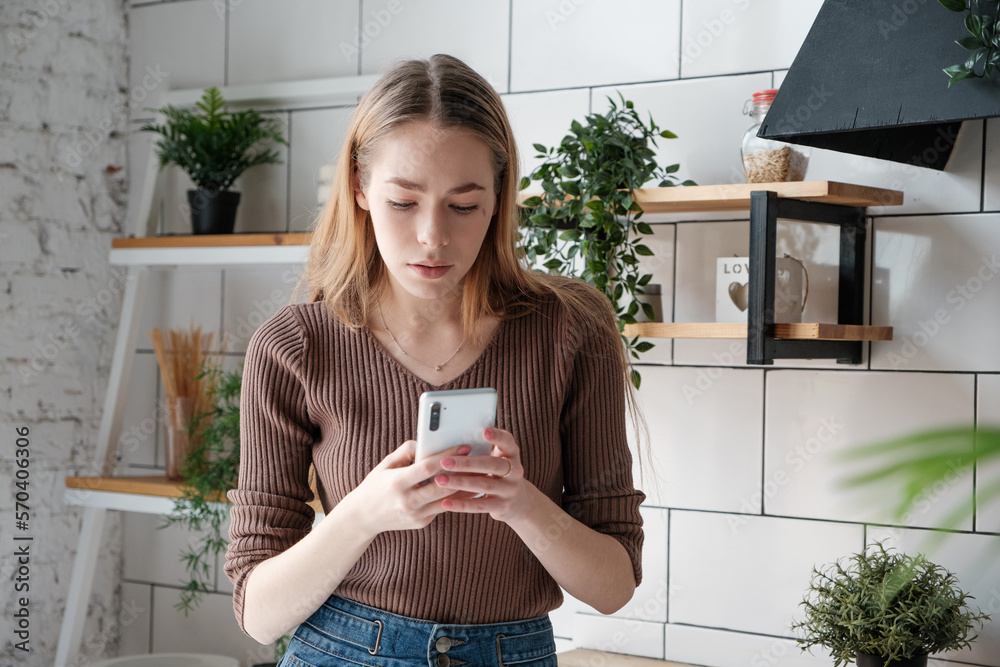 Pensive Caucasian Young Woman With Long Blonde Hair Holding Mobile 