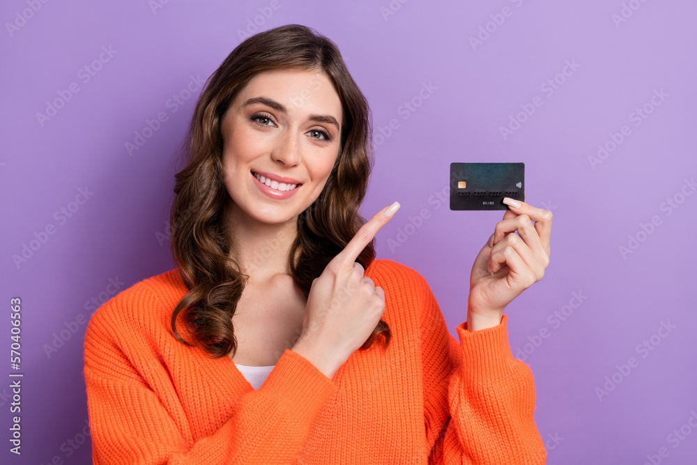 Photo of adorable stunning rich lady wear trendy orange clothes presenting new bank card for shopping isolated on purple color background Photo of adorable stunning rich lady wear trendy orange clothes presenting new bank card for shopping isolated on purple color background