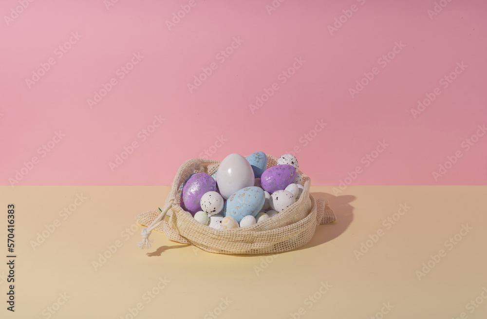 Composition with easter eggs in crochet organic shopping bag against two colors pastel background. Creative easter holiday concept.