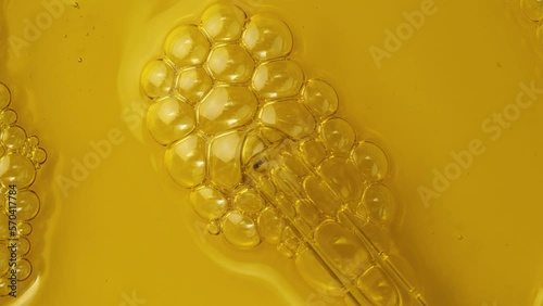 Pipette and natural oil. Foamed oil. Air bubbles in liquid. Oxygen enrichment. Beauty laboratory. Top view. Macro shot. Alternative medicine. Natural extract. 