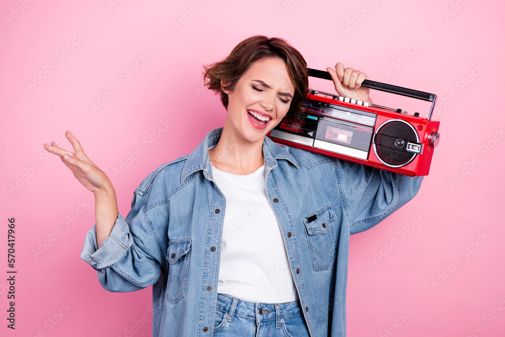 Photo of dreamy shiny woman wear jeans shirt enjoying songs boom box isolated pink color background Photo of dreamy shiny woman wear jeans shirt enjoying songs boom box isolated pink color background