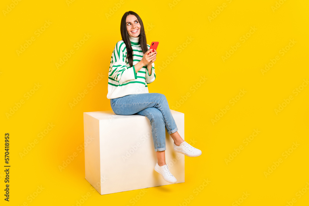Fototapeta premium Full length photo of positive lovely lady wear stylish clothes look empty space interesting offer isolated on yellow color background