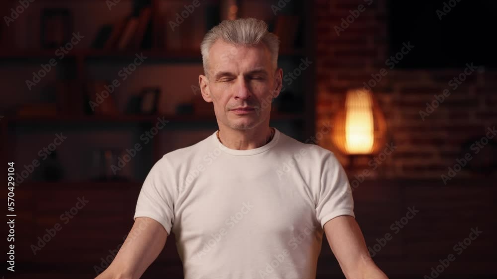 Yoga at home. The gray-haired man does yoga at home, doing asanas. Sports, stretching, gymnastics of an elderly man. Healthy lifestyle in old age. Yoga at home. The gray-haired man does yoga at home, doing asanas. Sports, stretching, gymnastics of an elderly man. Healthy lifestyle in old age.