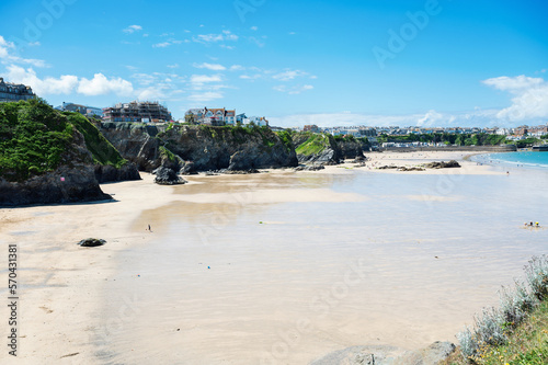 Beautiful Newquay beach with blue sea, stone cliffs and white sand in Cornwall, south west England, selective focus photo