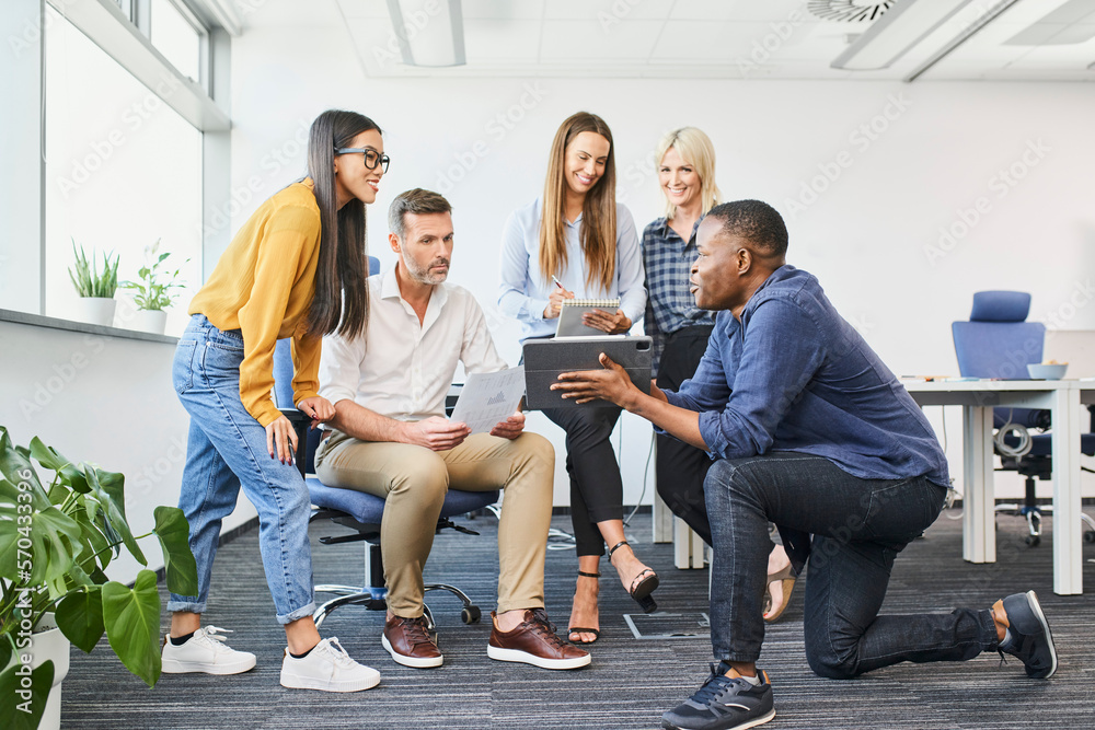 Fototapeta premium Young businessman pitching business ideas to group of people at modern coworking office