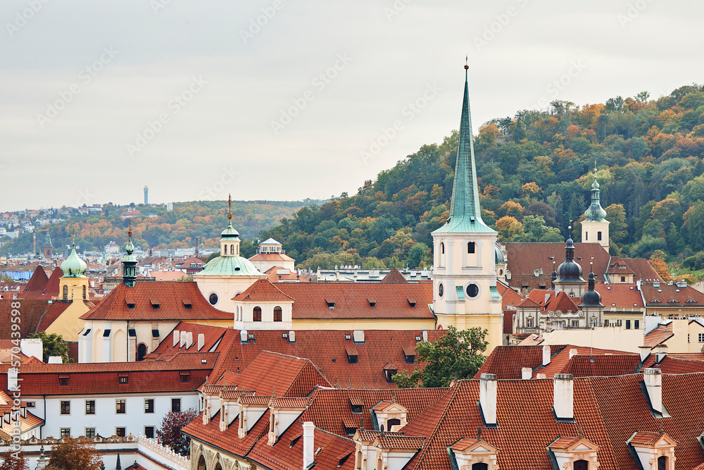 Orange tile roofs and church view, and historical buildings in Prague.