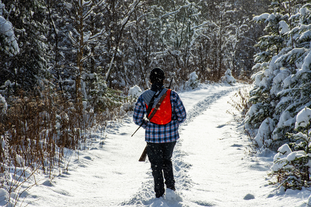 Young man hunting small game in the forest on a cold winter day