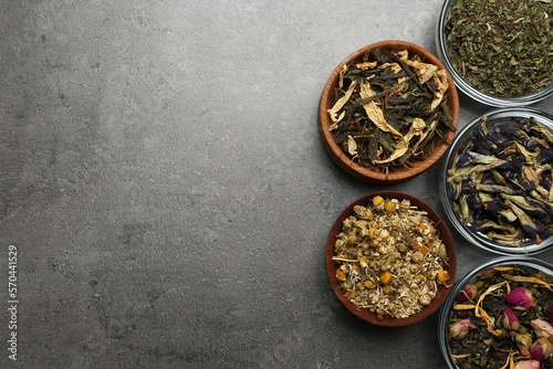 Flat lay composition with different dry teas on grey table, space for text