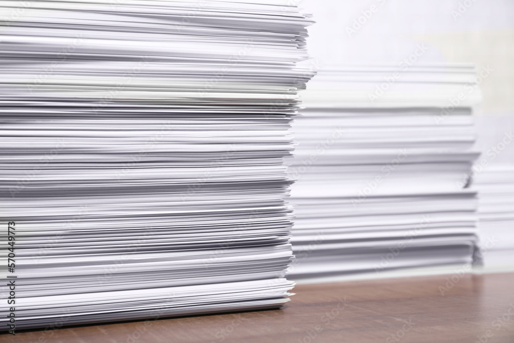Stacks of white paper sheets on wooden table, space for text Stacks of white paper sheets on wooden table, space for text