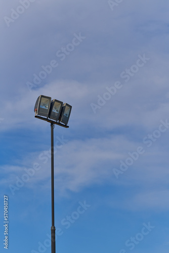 industrial light bulbs on pole with blue sky and cloud background
