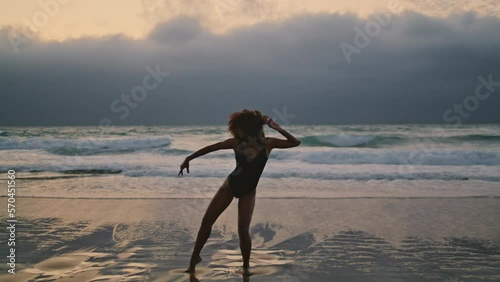 Girl dancing beach darkness at summer evening. Woman performer moving body.