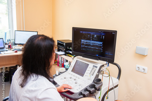 Medical specialists near ultrasound machine in the hospital ward.