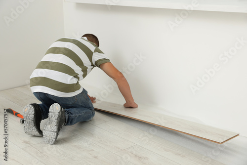 Professional worker installing new laminate flooring indoors